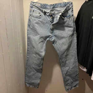 Ljusblå jeans från Zara, strl 44 - Säljer ett par ljusblå jeans från Zara i klassisk femficksmodell. Jeansen har raka ben och normal passform, tillverkade i bomullsdenim. Perfekta för en avslappnad och stilren look.