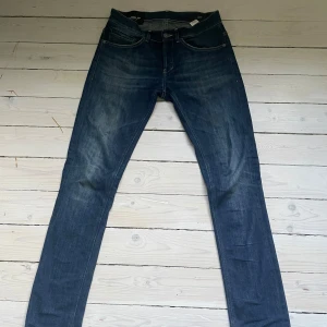 Mörkblå Dondup Jeans Storlek 30 - Snygga mörkblå jeans från Dondup i klassisk denim. Modellen har smal passform och diskreta slitningar. Dom är i bra skick och har inte använts mycket. Storlek 30.