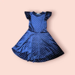 Mörkblå sammetsklänning H&M - Supersöt mörkblå sammetsklänning från H&M med glittriga prickar och volangärmar. Klänningen har rund halsringning och ett svängigt kjolparti som ger en riktigt fin siluett. Perfekt för dig som vill sticka ut lite extra!