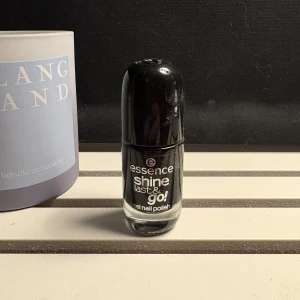 Essence svart nagellack Shine Last & Go - Essence Shine Last & Go gel nagellack i färgen 46 Black Is Back. Djupsvart, glansig finish och vegansk formula. Kommer i en smidig glasflaska med rundad svart plastkork. Perfekt för dig som vill ha riktigt svarta naglar med lång hållbarhet.