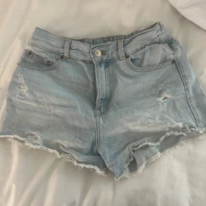 Ljusblå jeansshorts med slitningar - Snygga ljusblå jeansshorts med slitna detaljer och fransig kant. Shortsen är midwaist och är från Zara.