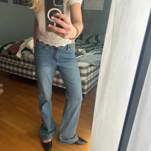 Blå bootcut jeans med låg midja - Säljer ett par klassiska blå jeans med bootcut-modell och låg midja. Jeansen har fem fickor, normal passform och är tillverkade i denim. Perfekta för en avslappnad och trendig look. Köpte i våras i usa använda en gång