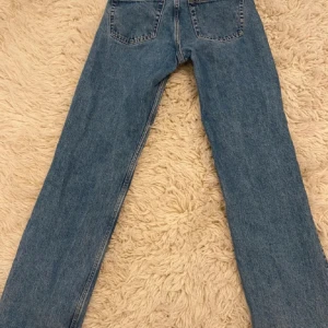 Weekday arrow low straight - Klassiska blå jeans från Weekday i stl 24/30 med raka ben och normal passform. Jeansen har fem fickor och stängs med dragkedja och knapp. Perfekta för en avslappnad stil och lätt att matcha med olika toppar. Köparen står för frakten + använder köp nu funktionen!