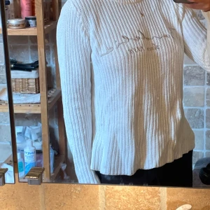 Vit stickad tröja från Bondelid - Säljer en vit, grovstickad tröja från Bondelid i storlek XS. Tröjan har broderad logga framtill, rund halsringning och långa ärmar. Perfekt för dig som gillar en klassisk och chill stil med snygga detaljer.