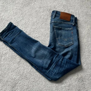 Replay jeans - Säljer nu dessa väldigt unika Replay anbass aged 05, går knappt att få tag på och har sjukt feta slitningar samt fades. Skicket är bra förutom att vissa trådar i slitningarna har släppt(se bild 4&5)