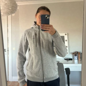 Superfin huvtröja från Sail Racing!! - Hej! 💗Jag säljer nu en snygg grå huvtröja från Sail Racing med dragkedja framtill och en praktisk huva. Superfin men säljs för att den dessvärre inte längre kommer till användning. Den är i bra skick, tecken på användning förkommer men den har inga defekter!! Den är i storlek 176 vilket motsvarar cirka strl s/m i vanlig storlek skulle jag säga, den passar mig bra som brukar ha strl s/m. Nypris 999 kr. Kontakta gärna vid fler bilder eller andra funderingar!! 💗💗Pris går att diskuteras!! 