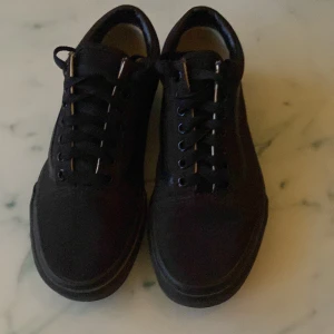 Svarta sneakers från Vans - Snygga svarta sneakers från Vans med klassisk design och snörning. Skorna har en brun sula med det ikoniska mönstret för bra grepp. Perfekta för en avslappnad stil.