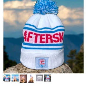 Vit mössa med blå och röd text - Afterski mössa som är köpt i fjällen och endast använd under en vecka kontakta mig för egna bilder om du är intresserad ❤️