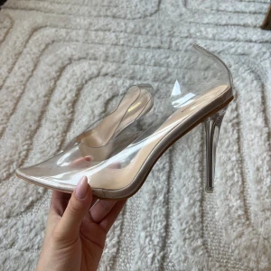 Transparenta klackskor - Snygga transparenta klackskor med spetsig tå och hög klack. Perfekta för att ge en elegant touch till din outfit. Skorna har en modern design med en genomskinlig finish. Oanvända men en del av klacken saknas. 