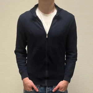 Massimo Dutti tröja - Säljer en stilren mörkblå massimo dutti kofta med dragkedja. Perfekt för både vardag och fest. Tröjan är i storlek S men passar S-XS. Nypris 999kr, köp för endast 350kr