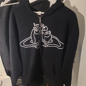 Svart hoodie från Broken Planet - Säljer en svart hoodie från Broken Planet med ett unikt vitt tryck på framsidan och texten 'I'm going to outer space' på ärmen. Hoodien har dragkedja och en bekväm passform.