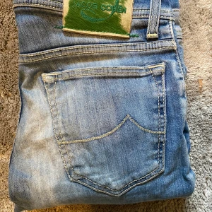Blå jeans från Jacob Cohen - Snygga blå jeans från Jacob Cohen med klassisk femficksdesign. Jeansen har en lätt tvättad look och slim passform. Tveka inte att ställa frågor! Size 30 och bra skick