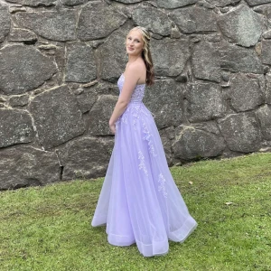 Lavendel offshoulder balklänning - Säljer nu min fina balklänning! Endast använd en gång och är i bra skick. Är 168 och har på bilden 5-7cm klack. Går ej längre att hitta på hemsida. Nypris 2400