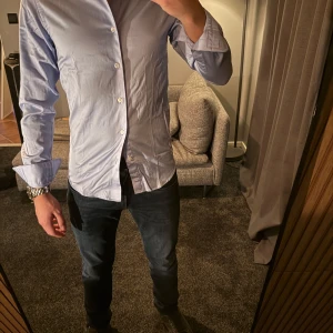 Ljusblå skjorta ifrån Dressmann - Riktigt snygg och stilren ljusblå skjorta från dressmann, den är i väldigt bra skick. Endast använd 1 gång. Den är i storlek xs och har en slim fit passform och jag som bär denna är 174cm lång. Köpt för 599kr. Bara att höra av dig om du har några funderingar 🙌🏼Pris går att diskuteras vid snabb och smidig affär. 