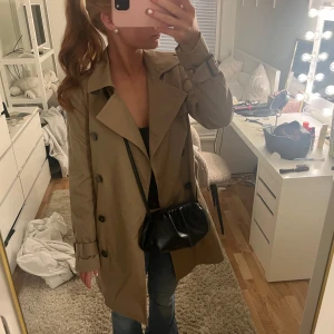 Beige trenchcoat från H&M - Säljer en stilren beige trenchcoat från H&M. Jackan har en klassisk design med knappar framtill och ett bälte i midjan. Perfekt för vår och höst. Den har långa ärmar och en tidlös look. Storlek 36 ifrån H&M!!💞Nästan helt ny, använd 1 gång. Nypris-599kr 