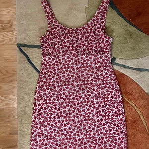 Röd blommig klänning från Afends - Säljer en söt röd och vit blommig klänning från Afends. Klänningen är ärmlös och har en kort längd, perfekt för sommardagar. Tillverkad i ett bekvämt material med en fin passform. Har lite slitage vid botten av dragkedjan men annars i bra skick 🌺