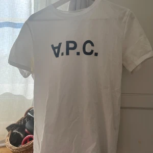 Vit t-shirt från A.P.C. - Säljer en stilren vit t-shirt från A.P.C. med deras logga tryckt i svart på bröstet. Inga defekter och bra skick. Skriv vid funderingar