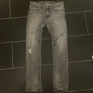 Grå jeans från Tommy Jeans - Snygga grå jeans från Tommy Jeans med slitna detaljer och en modern look. Passar riktigt bra, hör av er om ni har några funderingar☺️