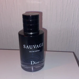 Sauvage Eau de Parfum från Dior - Säljer en flaska Sauvage Eau de Parfum från Dior. Flaskan är elegant med en mörkblå ton och har en stilren design. Korken är svart med Dior-loggan på toppen. Perfekt för den som vill ha en tidlös och maskulin doft. OBS!! Den är använd 
