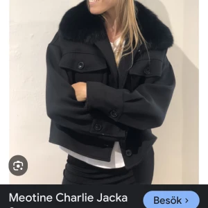 Svart jacka från Meotine - Snygg svart jacka från Meotine med en lyxig pälsdetalj på kragen. Jackan har en croppad passform och knappar framtill. Perfekt för att ge din outfit en stilfull touch.