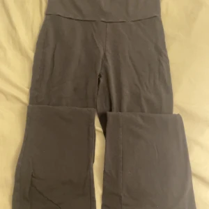 Grå byxor från Gina Tricot - Snygga grå byxor från Gina Tricot med låg midja. Perfekta för en avslappnad stil. Tillverkade i ett mjukt och bekvämt material. Kan vikas ner vid höften och är flareade vid smalbenen.