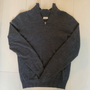 Grå tröja med dragkedja från John Henric - Snygg grå tröja från John Henric med dragkedja vid halsen. Perfekt för en stilren look. Tröjan har långa ärmar och är tillverkad i ett mjukt material som ger en bekväm passform.