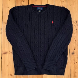 Marinblå kabelstickad tröja Ralph Lauren -  bra skick och kvalité 📬Jag postar inom 24 timmar efter köp 🐑100% bomull  📏storlek 14-16/L i barnstorlek, passar perfekt till XS i vuxen storlek📐41cm axelbredd, 58cm full längd, 55cm ärmlängd ☺️skriv om du har några funderingar eller för fler bilder