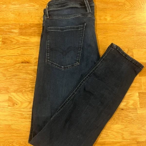 Mörkblå jeans från Replay - Snygga mörkblå jeans från Replay med klassisk femficksdesign. De har en slim passform och är tillverkade i slitstarkt denim. Perfekta för en stilren look.