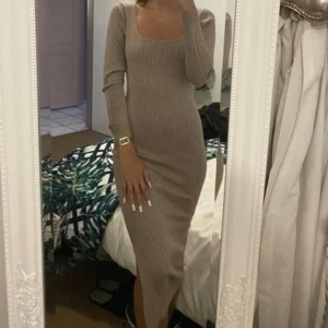Beige/rosa  ribbad klänning - Säljer en stilren beige/ rosa skiftning ribbad klänning med lång ärm och en smickrande tight passform. Perfekt för en elegant look. Klänningen har en rundad halsringning och är gjord i ett mjukt material.