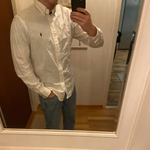 Vit skjorta Ralph Lauren - En väldigt fin raffe skjorta i mycket gott skick. Enda defekten är lite deodorant avfärgning i armhålorna som knappt syns och definitivt inte syns vid användning🙌  Skjortan är i storlek L👌