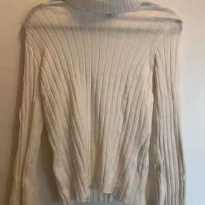 Vit ribbad polotröja - Säljer en stilren vit ribbad polotröja med långa ärmar. Perfekt för kyligare dagar och enkel att matcha med olika outfits. Den är i nyskick från Hm i storlek XS