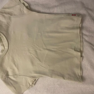 Ljusgrön t-shirt från Levi's - Säljer en stilren ljusgrön t-shirt från Levi's med deras ikoniska logga tryckt på framsidan. T-shirten är kortärmad och gjord i mjuk bomull, perfekt för en avslappnad look. Passar utmärkt till jeans eller shorts. Skicka ett meddelande vid intresse!