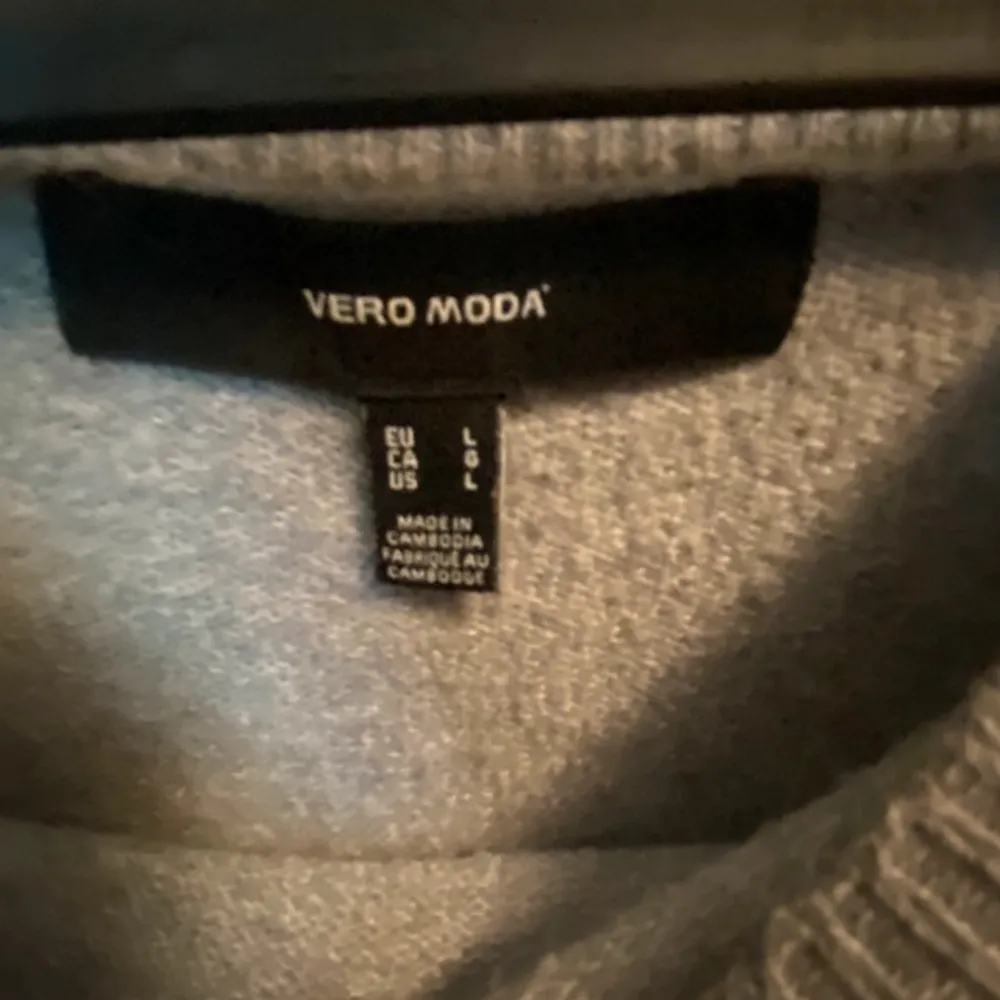 Säljer en mysig grå stickad tröja från Vero Moda. Perfekt för kyliga dagar med sin mjuka och bekväma passform. Tröjan har långa ärmar och en rund halsringning. Ett måste i garderoben för en stilren look.. Neuletakit & Villapaidat.