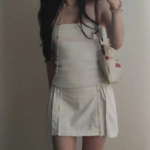 Mini kjol vit  - Säljer min fina lågmidjade kjol med två dragkedjor där framme då den inte passar längre. Den har två snören man kan knyta runt midjan eller låta hänga. Fanns inbyggda shorts i kjolen men jag klippte bort dem. 