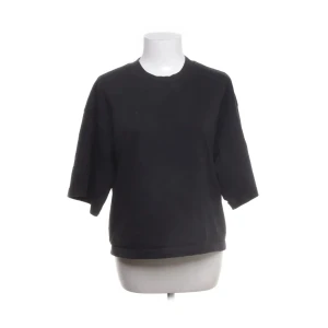 Svart kortärmad tröja - Säljer en stilren svart tröja med korta ärmar. Perfekt för en avslappnad look. Tröjan har en rund halsringning och en bekväm passform.