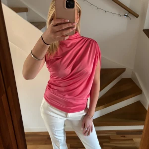 Rosa topp - Säljer en snygg rosa topp från Lumina. Toppen har en oneshoulder-stil. Perfekt för att piffa upp garderoben med något unikt och stilrent!