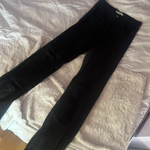 Svarta jeansbyxor - Snygga svarta bootcut jeans med slits på benen Byxorna har fickor både fram och bak samt en knapp och dragkedja i gylfen.