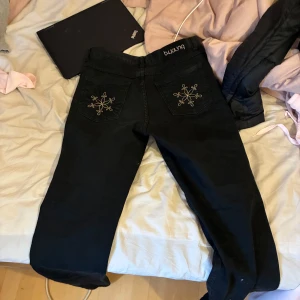 Svarta jeansbyxor från b.young - Snygga svarta jeansbyxor från b.young med broderade detaljer på bakfickorna. Byxorna är middle waist. Säljes för dom ej passade, köpta på secondhand för 300kr, ej använda av mig bästa testade 