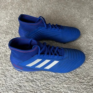 Adidas Predator 19.3 FG - Nyskick, bara smuts på undersidan från de två gånger de varit på gräs. (Skorna kommer puttsas innan leverans) Köpte inför nästa säsong men blev aldrig av på grund av skada så de har bara legat på hyllan senaste 3 åren. Det är en gammal predator model och även den som slog igenom, som inte längre tillverkas.