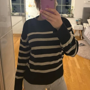 Svart och vit randig tröja - Säljer en svart och vit randig tröja med långa ärmar. Tröjan har en klassisk design med breda ränder och ribbade muddar vid ärmslut och nederkant. 