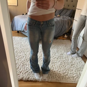 Lowwaist bootcut jeans - Säljer ett par vintage Gina ljusblå bootcut jeans med slitningar och snygga bakfickor. Mina favorit jeans men säljer pga de är för små i midjan, jag är 164 och de är lite långa för mig. jag har själv sytt om de till lite mer bootcut och lagat de i mellan bena på bild 4, sen är det lite slitage längst ner på benen. Priset går att diskutera ❤️❤️