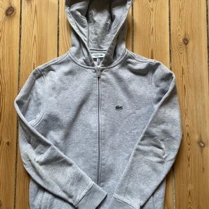 Grå hoodie från Lacoste - Säljer en grå hoodie från Lacoste, storlek 164 cm 