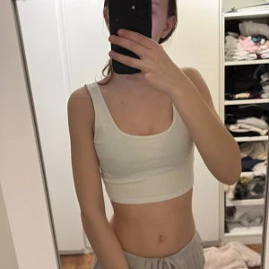 Vit ribbad linnetopp från Gina Tricot  - Säljer en snygg vit ribbad linnetopp från Gina Tricot. Väldigt skön, stretchig och söt. Passar till det mesta, både vintertid och sommartid. Helt enkelt ett plagg du kan använda hela tiden, under något annat eller som den är. Storlek XS. 