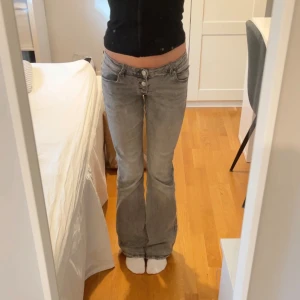 Low waist jeans - Snygga grå jeans från Gina Tricot med bootcut-stil och låg midja. Mycket fint skick, det enda är lite slitningar längst ner (se sista bilden) storlek XS/158, midjan går att justera, priser kan diskuteras!