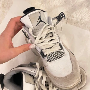 Nike Air Jordans i vitt och svart - Snygga Nike Air Jordans i vitt och svart med klassisk snörning och ikonisk logga på plösen. Skorna har en sportig design med meshdetaljer och en robust sula. Perfekta för dig som älskar streetwear och vill ha en stilren look.