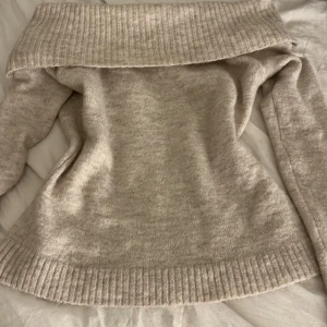 Beige offshoulder stickad tröja - Säljer en mysig beige stickad tröja med offshoulder-design. Tröjan har långa ärmar och ribbade kanter säljer pga ingen användning skriv för mer info🩷