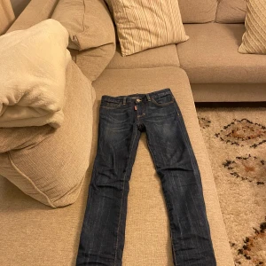 Mörkblå jeans från Dsquared2 - Snygga mörkblå jeans från Dsquared2 med klassisk femficksdesign och kontrasterande sömmar. Perfekta för en stilren look.
