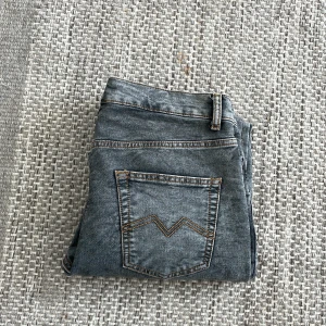 Grå jeansbyxor - Snygga grå jeans från monten . De har en rak passform och är perfekta för en avslappnad stil. Byxorna har en diskret tvättad look som ger dem en cool touch. Jeansen är uppsydda på längden ungefär 1 cm.