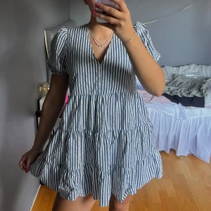 Randig klänning med volanger - Säljer en söt randig klänning med volanger och v-ringning. 