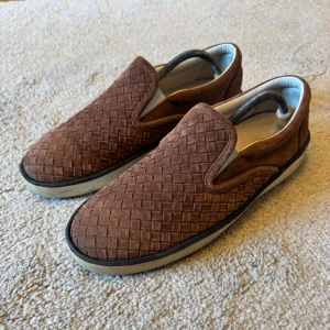 slip-ons från Bottega Veneta - Slip-ons / Loafers. Stört stilrena som passar till ALLT inför sommaren. Nyköpta men tyvärr var storleken lite för stor. De är 43 men upplevs snarare 44. Grymt skick, 9/10